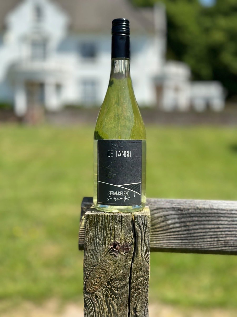 Fles De Tangh Sprankelend, Souvignier Gris, met het landhuis op de achtergrond